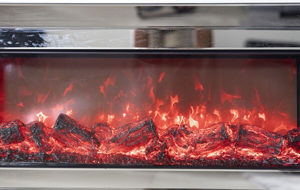 A glass fireplace with a visible fire.