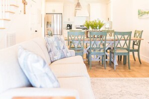 Una sala de estar moderna con un sofá, una mesa de comedor y sillas.