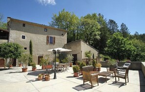 Relax in the patio area with comfortable seating and lush greenery.