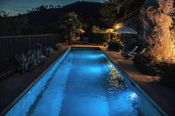 Relax by the serene pool surrounded by lush greenery and comfortable lounge chairs.