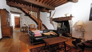 Una sala de estar acogedora con chimenea, una escalera y un comedor.