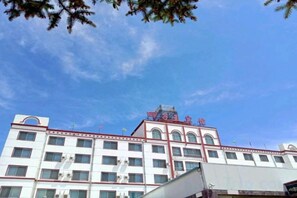 Un edificio de varios pisos con fachada plana, amplias ventanas y un cielo azul despejado.