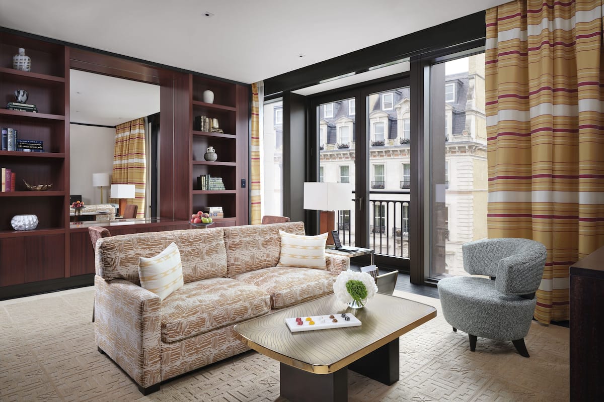 A modern living room with a patterned sofa, a coffee table, and a bookshelf.