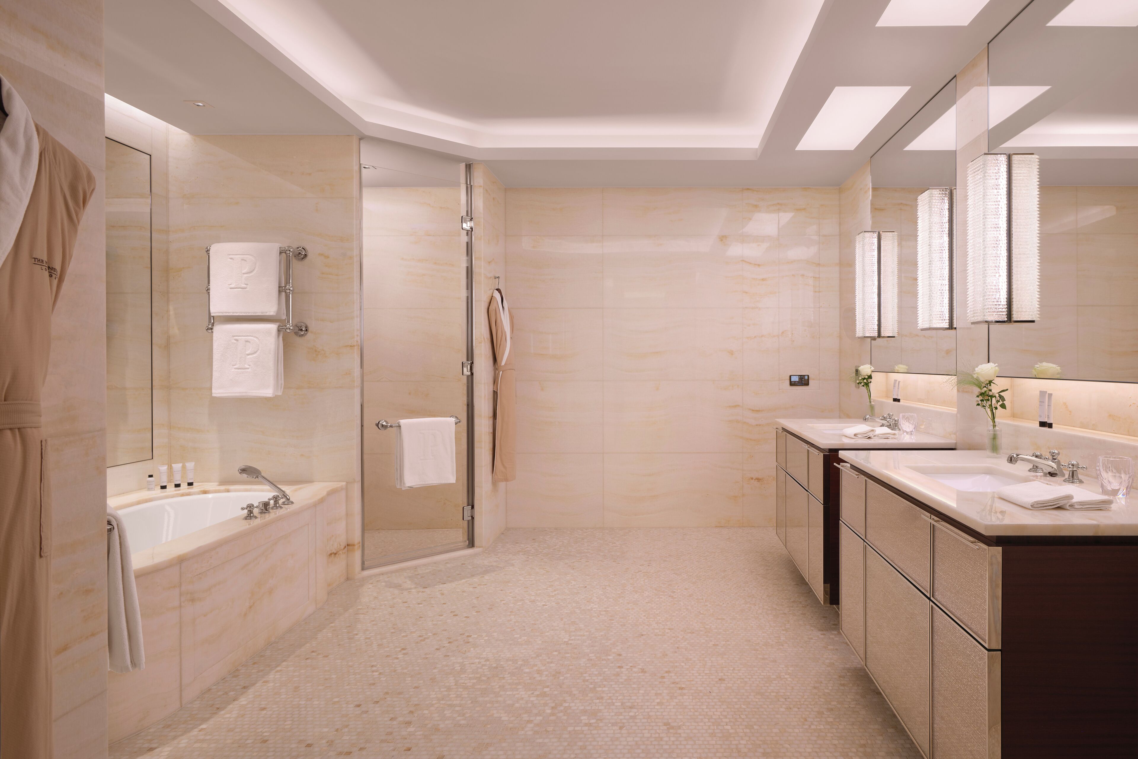 A modern bathroom with a glass-enclosed shower, a double sink vanity, and a large mirror.