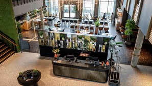 A spacious, modern hotel lobby with a reception desk, seating areas, and large windows offering views of the outdoors. - Quality Hotel Richard With (Hadsel)