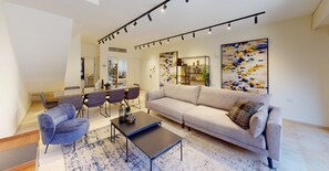 Ein modernes Wohnzimmer mit einer Couch, einem Couchtisch und einem Essbereich mit Stühlen und einem Tisch.