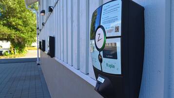 A parking meter with a QR code, a phone number, and the word "Kople" on it.