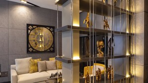 A modern living room with a white sofa, decorative pillows, and a wall-mounted clock. - Nish Palace Besiktas (Istanbul)