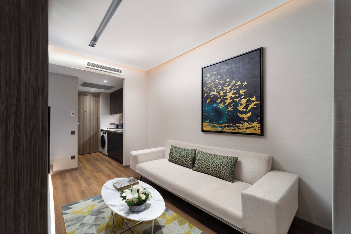 Una sala de estar moderna con un sofá, una mesa de centro y un cuadro en la pared.