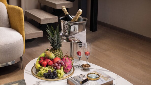 A fruit platter, champagne, and glasses on a marble table in a modern living room. - Nish Palace Besiktas (Istanbul)