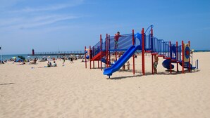 Un parque infantil en la playa con toboganes y estructuras para escalar.
