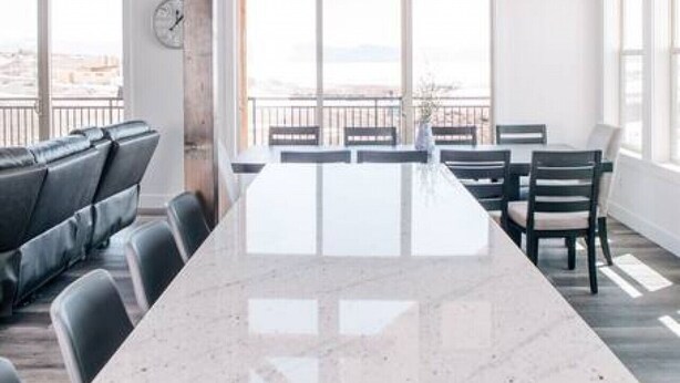 A spacious kitchen with a large island, modern pendant lighting, and large windows offering a view. - Unobstructed Lake Views! Bunk Room w/ Video Games! Ping Pong & Foosball! Extra Fridge & Freezer Space! (Fish Haven)