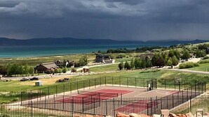 A residential area with houses, a basketball court, and a view of a large body of water under a cloudy sky. - Unobstructed Lake Views! Bunk Room w/ Video Games! Ping Pong & Foosball! Extra Fridge & Freezer Space! (Fish Haven)