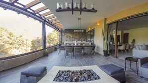 A spacious outdoor patio with a fire pit, dining area, and seating.