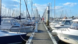 Ein Yachthafen mit einer Holzpromenade gesäumt von Booten.