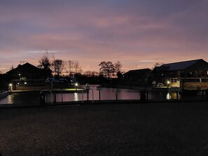 A waterfront property with a dock, a small building, and a large house with a porch. - New! River Bay - set on the waters edge - sleeps 4 (Brundall)