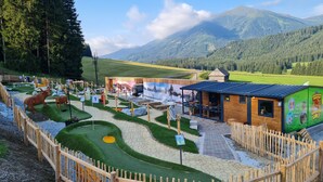 A rustic lodge with a wooden exterior, a dining area, and a scenic mountain backdrop. - Cozy vacation home, perfect for families - hiking, skiing on the doorstep (Hohentauern)