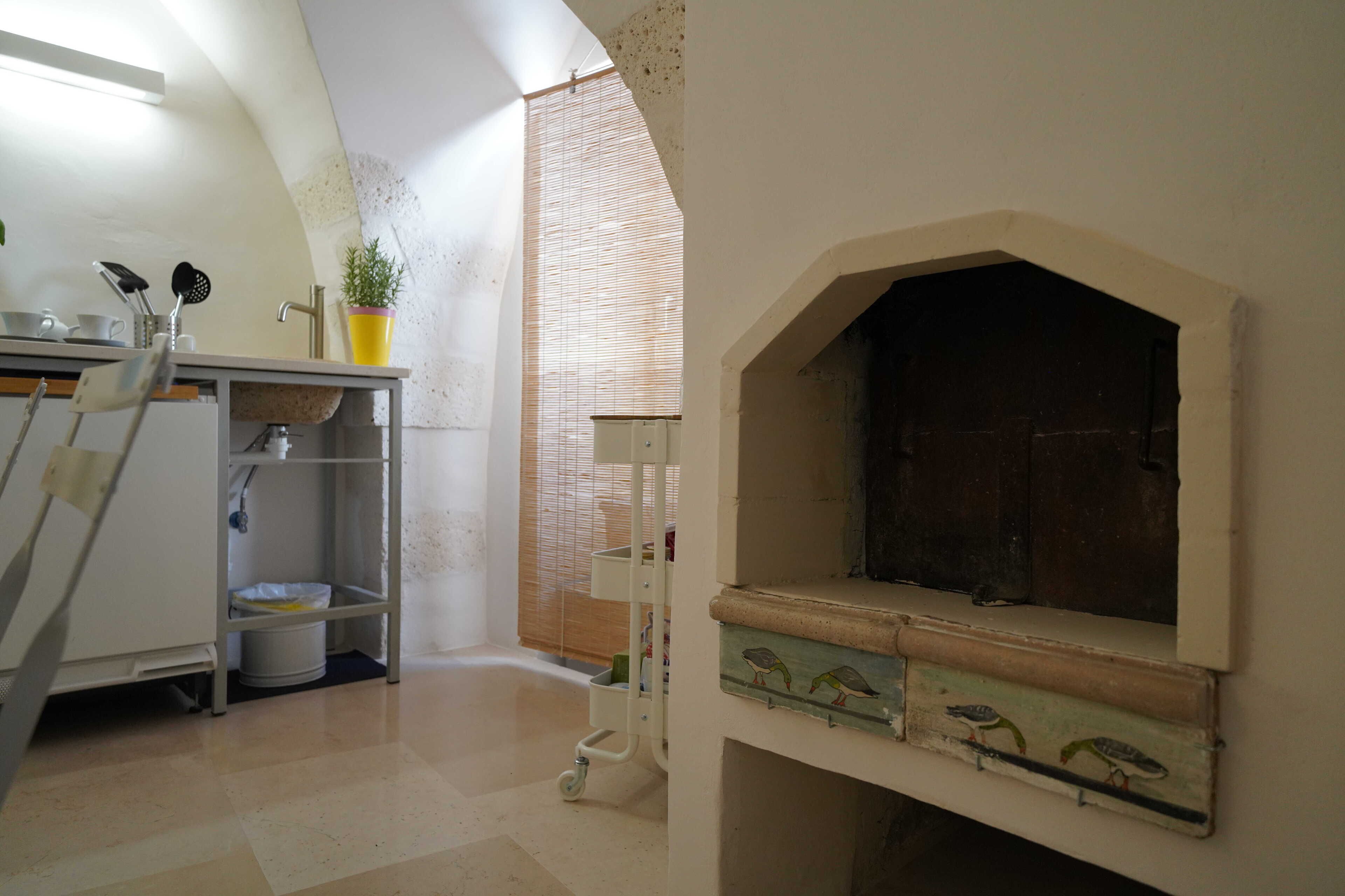 Een keuken met een ingebouwde oven, een spoelbak en een raam met zonwering.