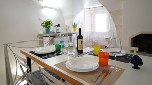Comedor con una mesa para dos, una botella de vino y diferentes copas.