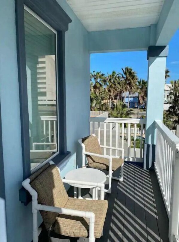 Relax on the balcony with a view of palm trees and a residential neighborhood.