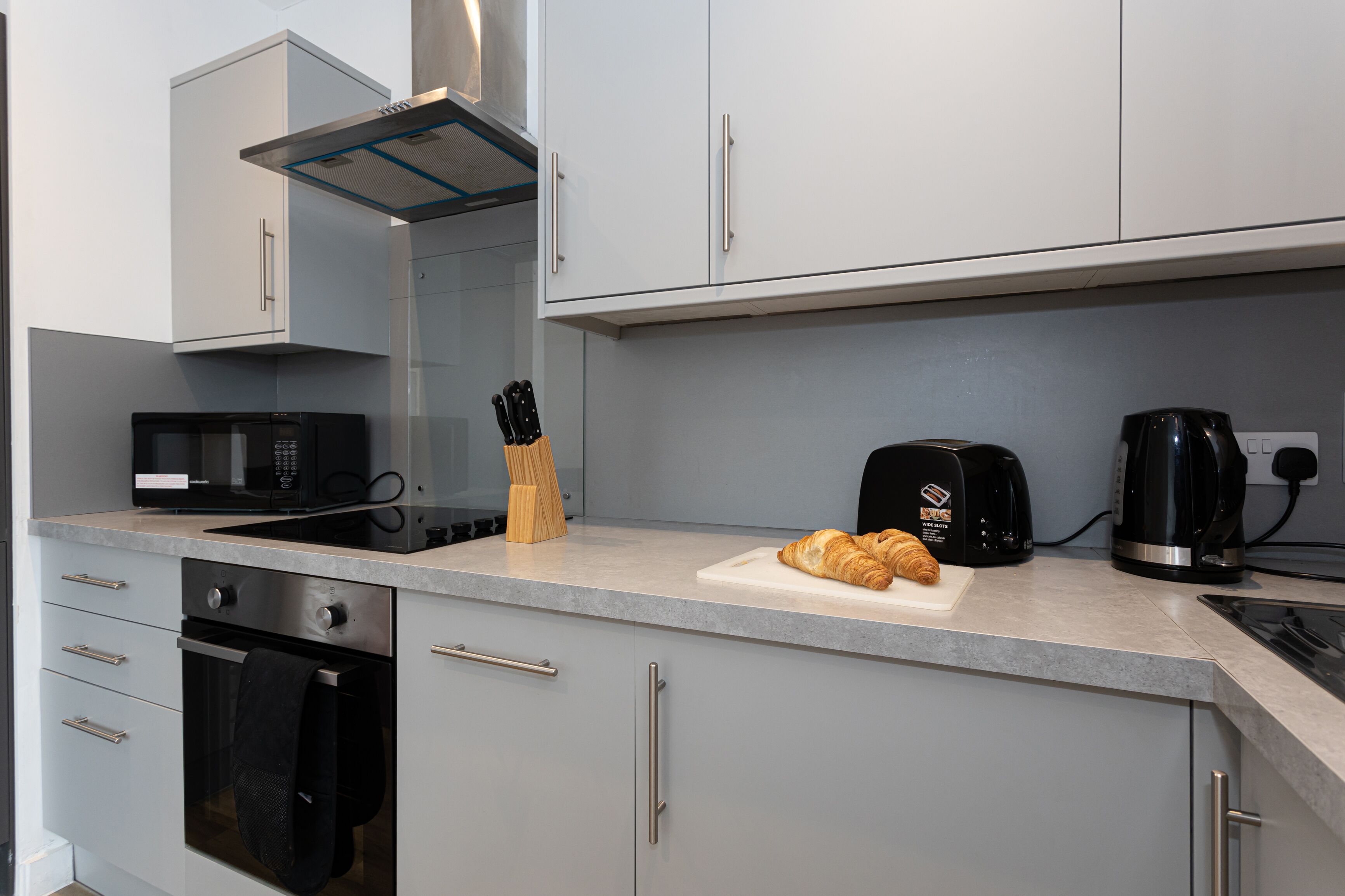A modern kitchen with a microwave, toaster, and coffee maker on the counter.