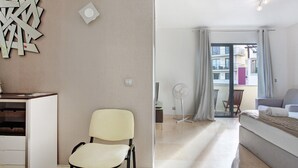 Une chambre moderne avec un lit, une chaise, un bureau et un balcon offrant une vue agréable.
