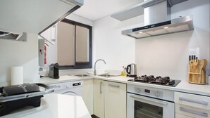 Une cuisine moderne équipée d’une cuisinière, d’un four, d’un évier et d’une fenêtre.