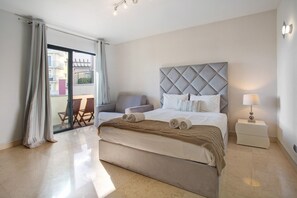 A bedroom with a large bed, a nightstand, a chair, and a view of the outside. - Studio Apartment 'Apartamento Forum View Studio' with Balcony and Wi-Fi (Funchal)