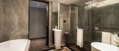 A modern bathroom with two freestanding tubs, a glass-enclosed shower, and a marble floor.