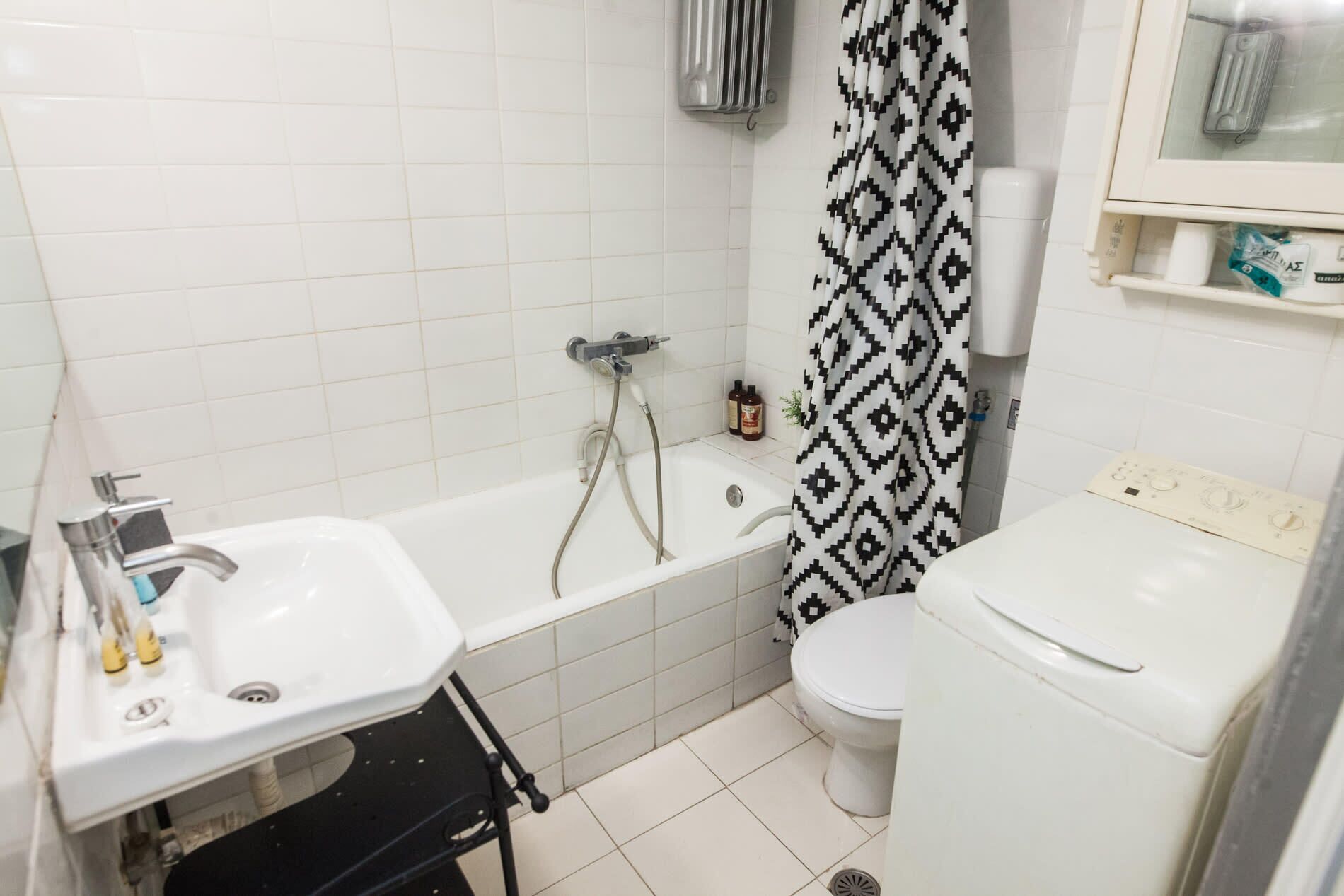 A bathroom with a bathtub, a toilet, and a sink.