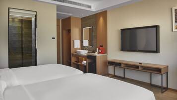 Una habitación de hotel con una cama grande, un escritorio, un lavamanos y un televisor.
