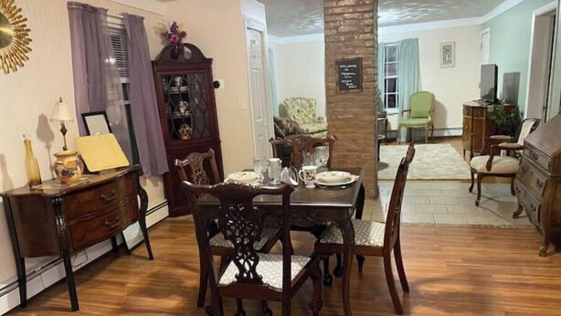 A dining area with a wooden table and chairs, a cabinet, and a decorative mirror.