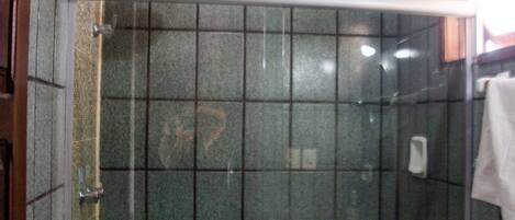 A bathroom with a glass-enclosed shower, a toilet, and a sink.