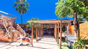Un patio con una pérgola de madera, escalones de piedra y una hamaca.