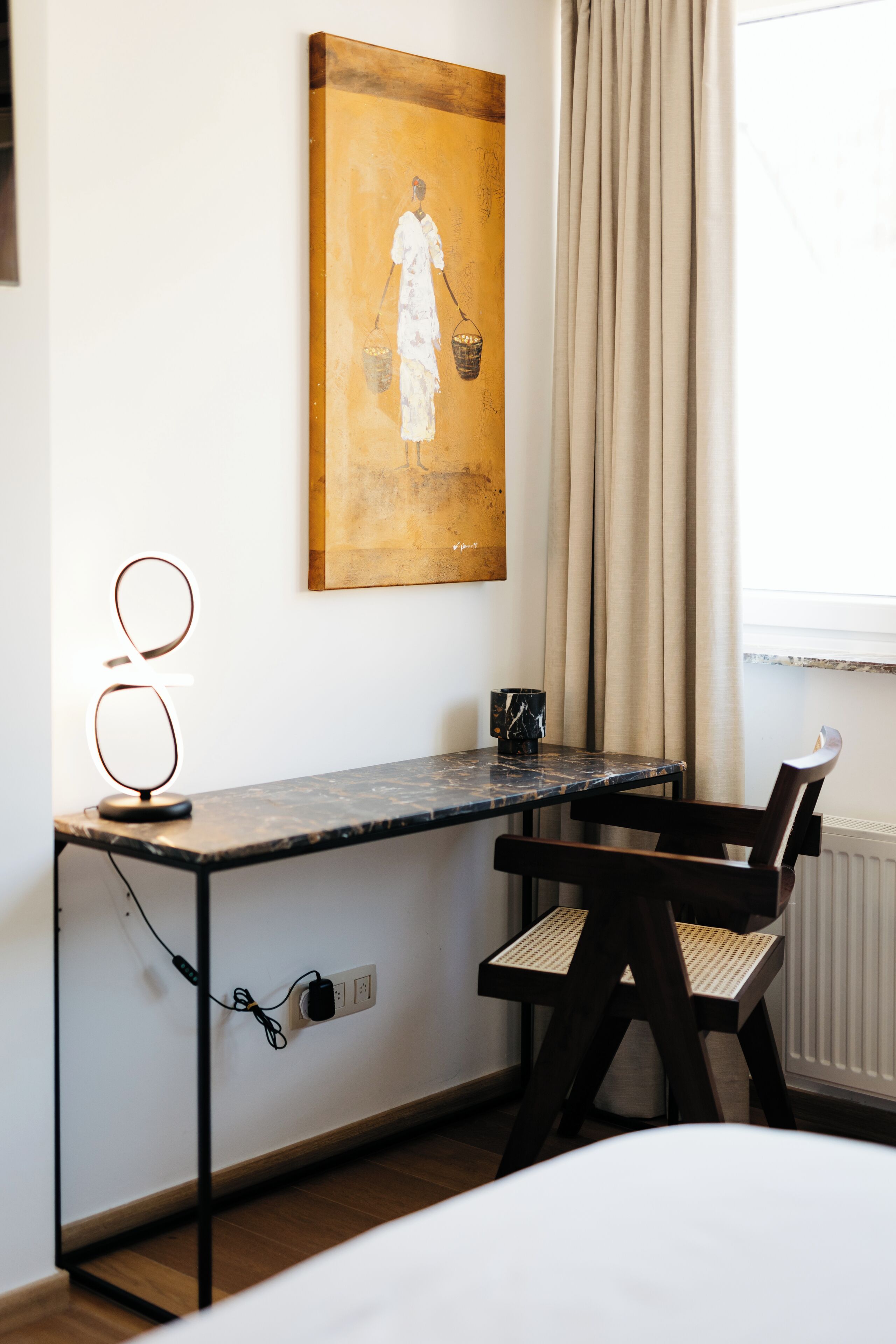 Une pièce comprenant un bureau, une chaise et un tableau accroché au mur.