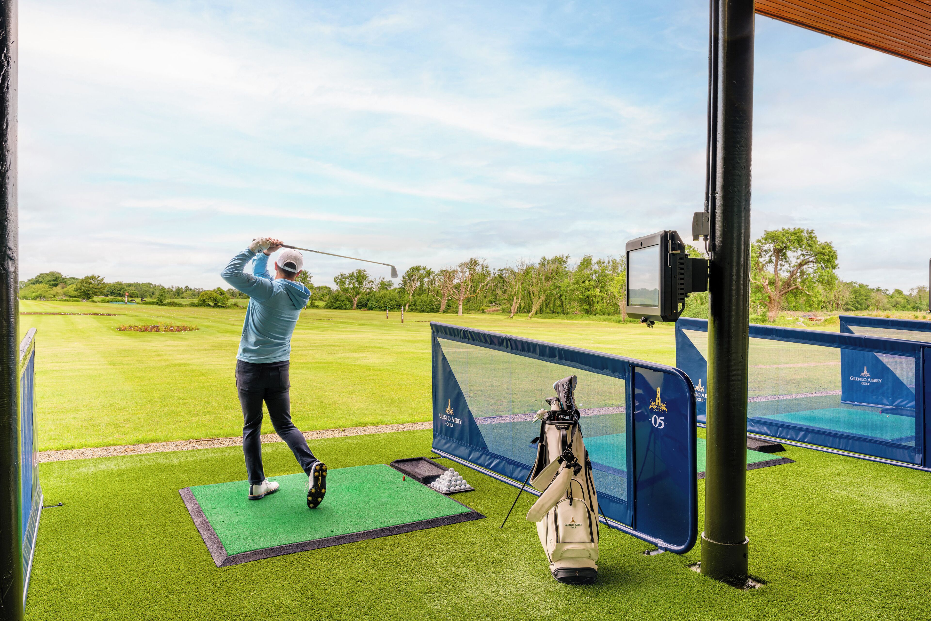 Un parcours de golf comprenant un espace de départ, un green d’entraînement et un sac de golf.