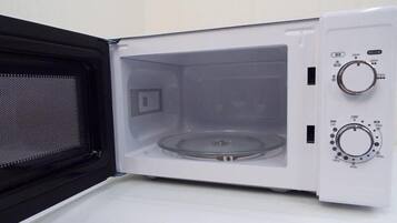 Um micro-ondas vazio, com botões de controle e porta de malha.