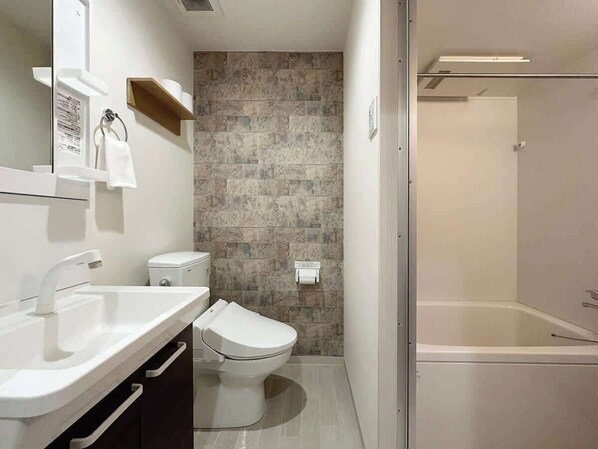 A modern bathroom with a white sink, toilet, and bathtub.