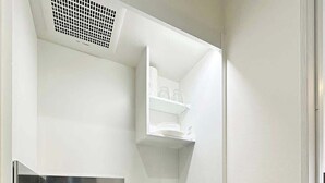 A compact kitchenette with a microwave, stove, sink, and storage cabinets.