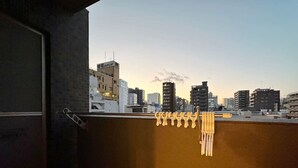 A balcony with a view of a cityscape at dusk. - Nagomi by b hotel | Comfortable Studio Stay N41 (Hiroshima City)