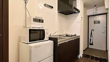 Kylskåp, mikrovågsugn, spishäll och grytor/köksredskap