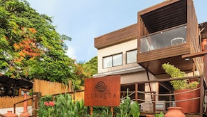 A wooden deck leading to a building with a sign reading "CORVETA ROYA".
