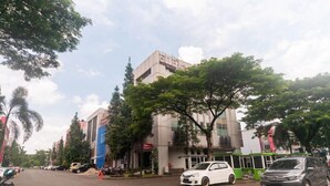A building with a sign that reads "BIRDS OF A FEATHER" and a green bus parked in front. - OYO 3216 Ellegan Residence (South Tangerang)