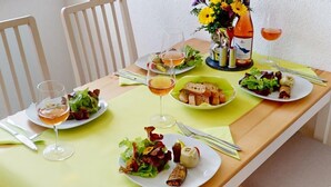 A dining table set with plates of food, glasses of wine, and a bottle of wine. - Vacation apartment Seenah - relaxation on Lake Constance & close to the Schmieder Klinik (Radolfzell am Bodensee)