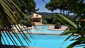 A swimming pool with lounge chairs and a building in the background. - Villa Lorna - 2 maisons - piscine privée (Aups)