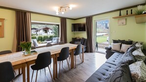Un salon moderne comprenant un coin repas, un canapé et un téléviseur.