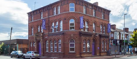 A red brick building with arched windows and a corner entrance.