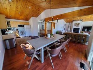 A spacious kitchen with wooden cabinets, a dining table with chairs, and a chandelier. - Upscale Lakehouse, Private Sauna, Great Views, Great Fishing! Pet-Friendly (Minden Hills)