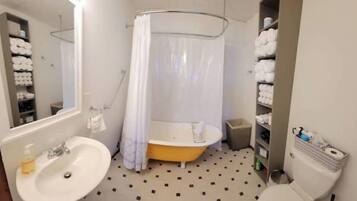 Een badkamer met een bad, een wastafel, een toilet en een douchegordijn.