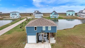 A residential area with houses, a dock, and a body of water. - Born To Beach - Beach view, cargo lift, 4 bedrooms, Sleeps 12 (Crystal Beach)